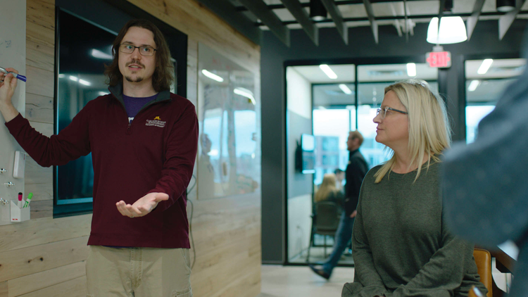 Two Surest employees collaborating in front of white board